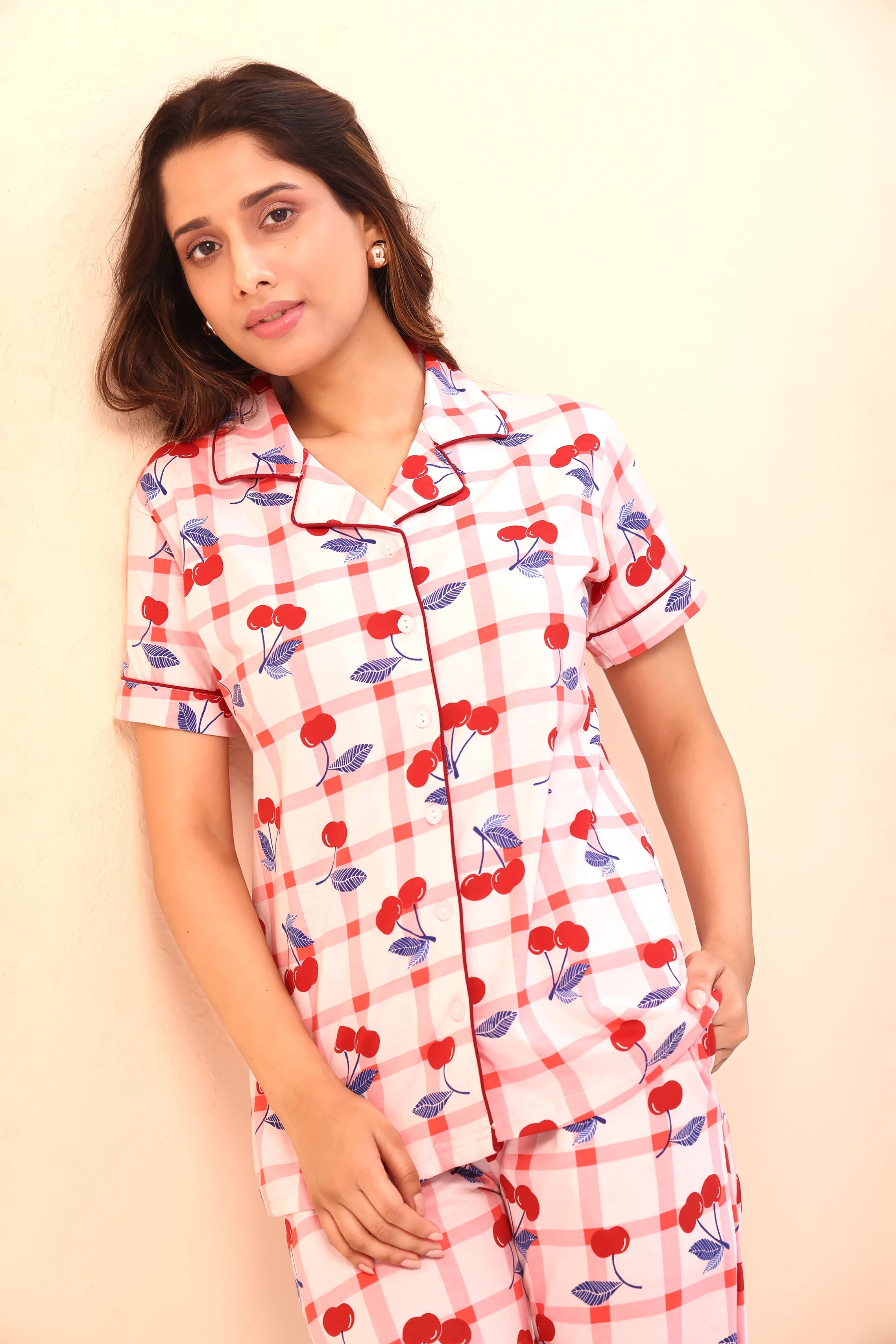 Young woman posing in cherry print Pyjama Set nightwear with a soft expression by NapStory.