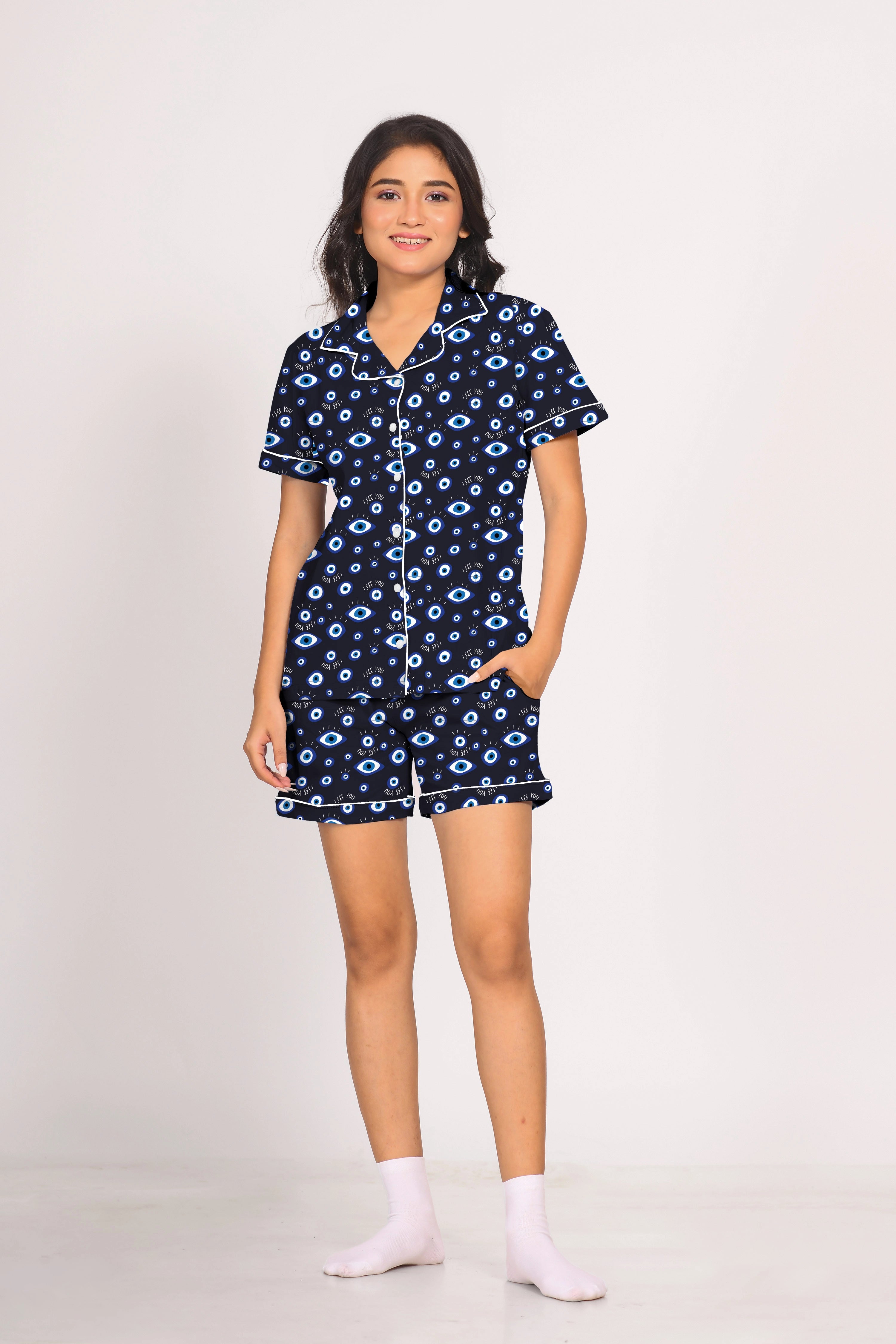 Full view of woman wearing Evil Eye Printed Shorts Set nightwear by NapStory, standing with one hand in pocket.