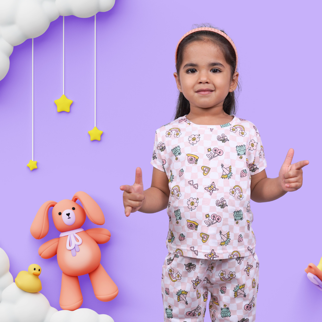 A baby girl in victorious pose wearing Summer Vibe Print Kids Unisex Nightwear by NapStory.