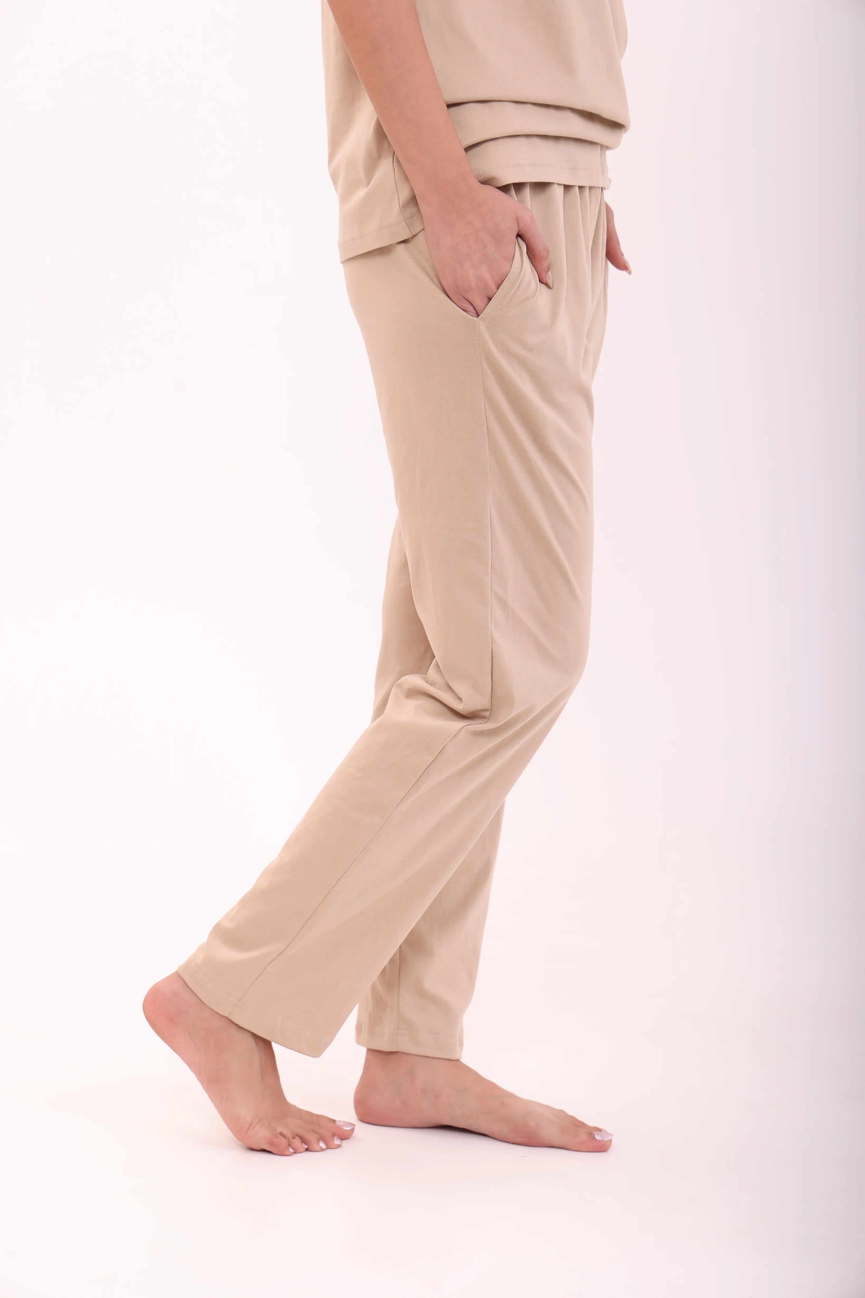 Woman in sand-coloured cotton pyjama with hand in pocket, cotton loungewear by NapStory