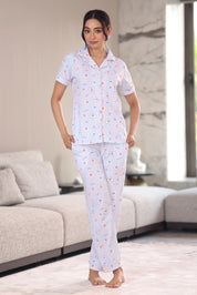 Woman wearing a patterned pajama set in a modern living room.