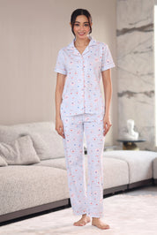 Woman wearing a patterned pajama set in a living room.