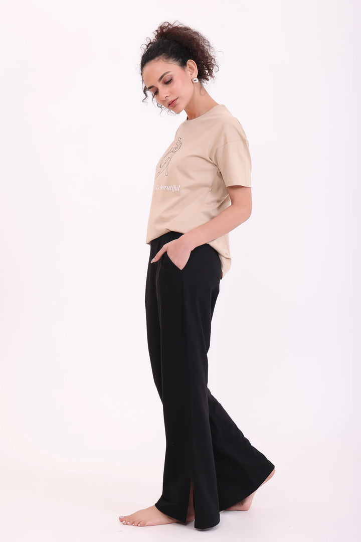 Woman posing in sand tee & black flared trousers 100% cotton comfortable nightwear by NapStory