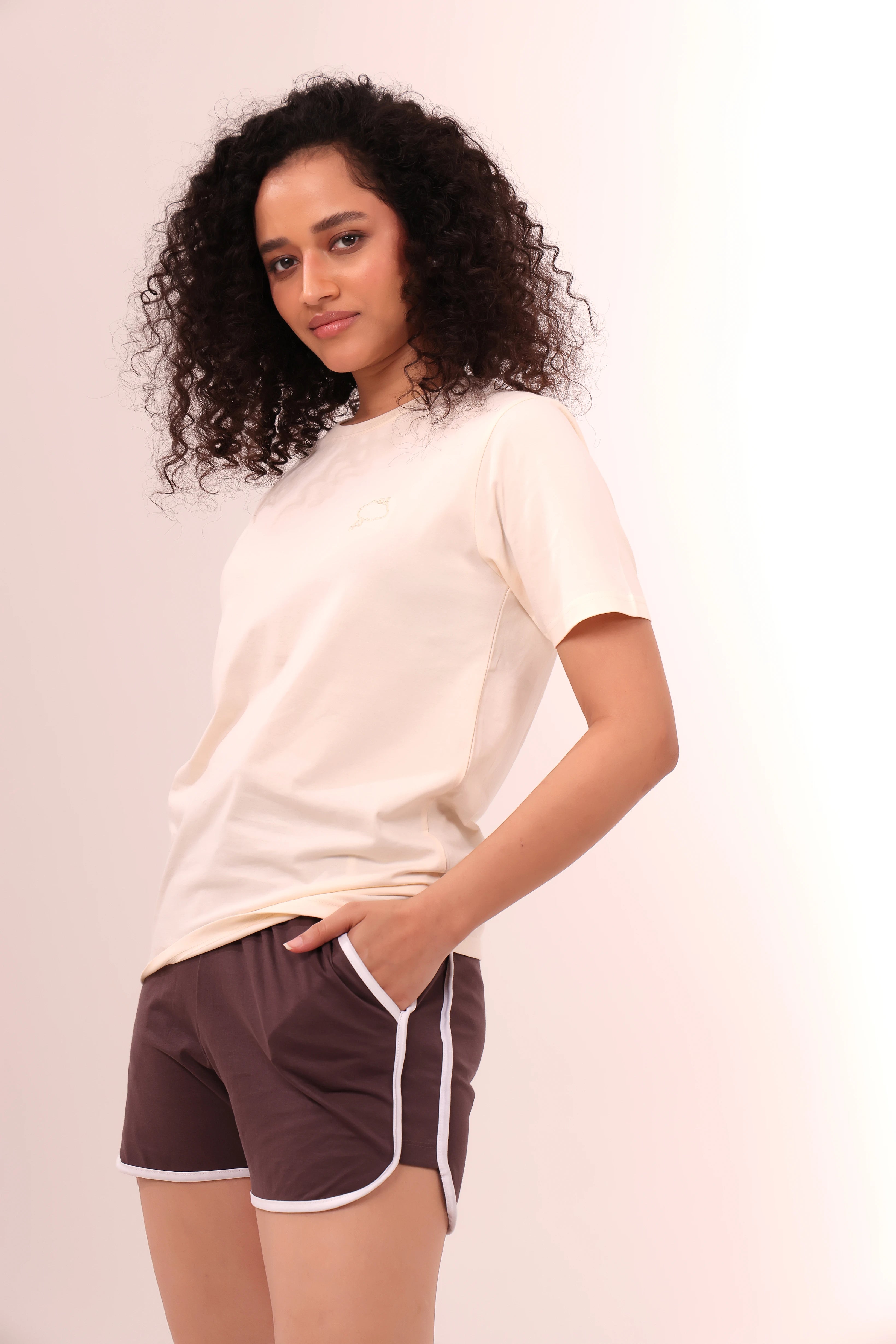 Woman posing in brown piped-up shorts and beige top, comfortable cotton loungewear by NapStory