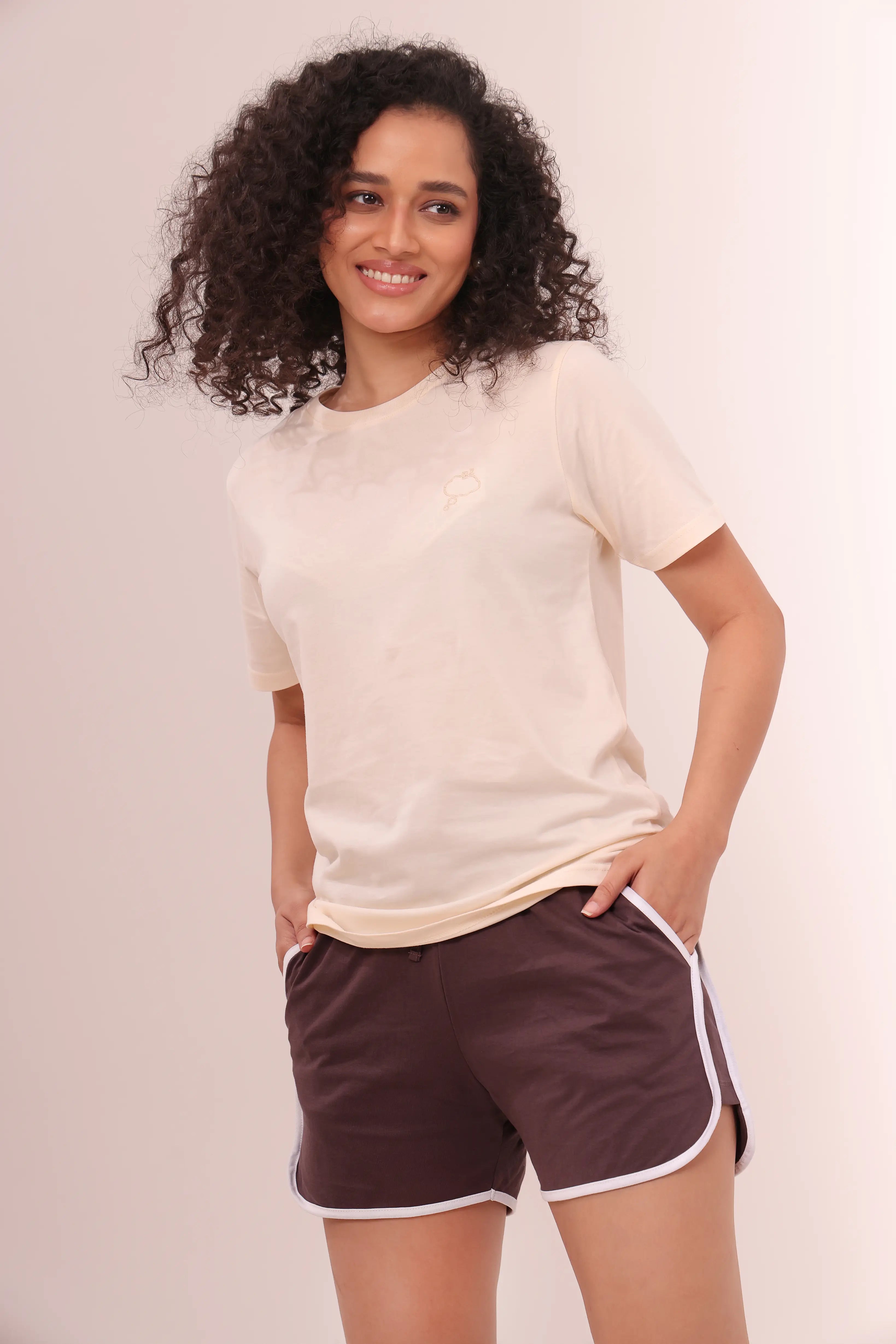 Woman smiling in brown piped-up shorts and beige cotton tee by NapStory