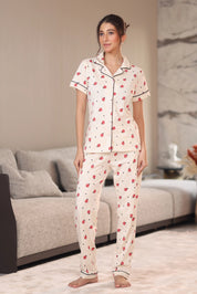 Woman wearing a pajama set with a heart pattern in a living room.