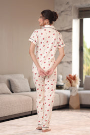 Woman wearing a patterned pajama set in a living room.