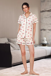 Woman wearing a shorts set with bug patterns in a living room.
