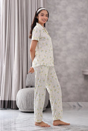 Woman wearing a Bunny print pajama set in a room with gray curtains and a marble floor.