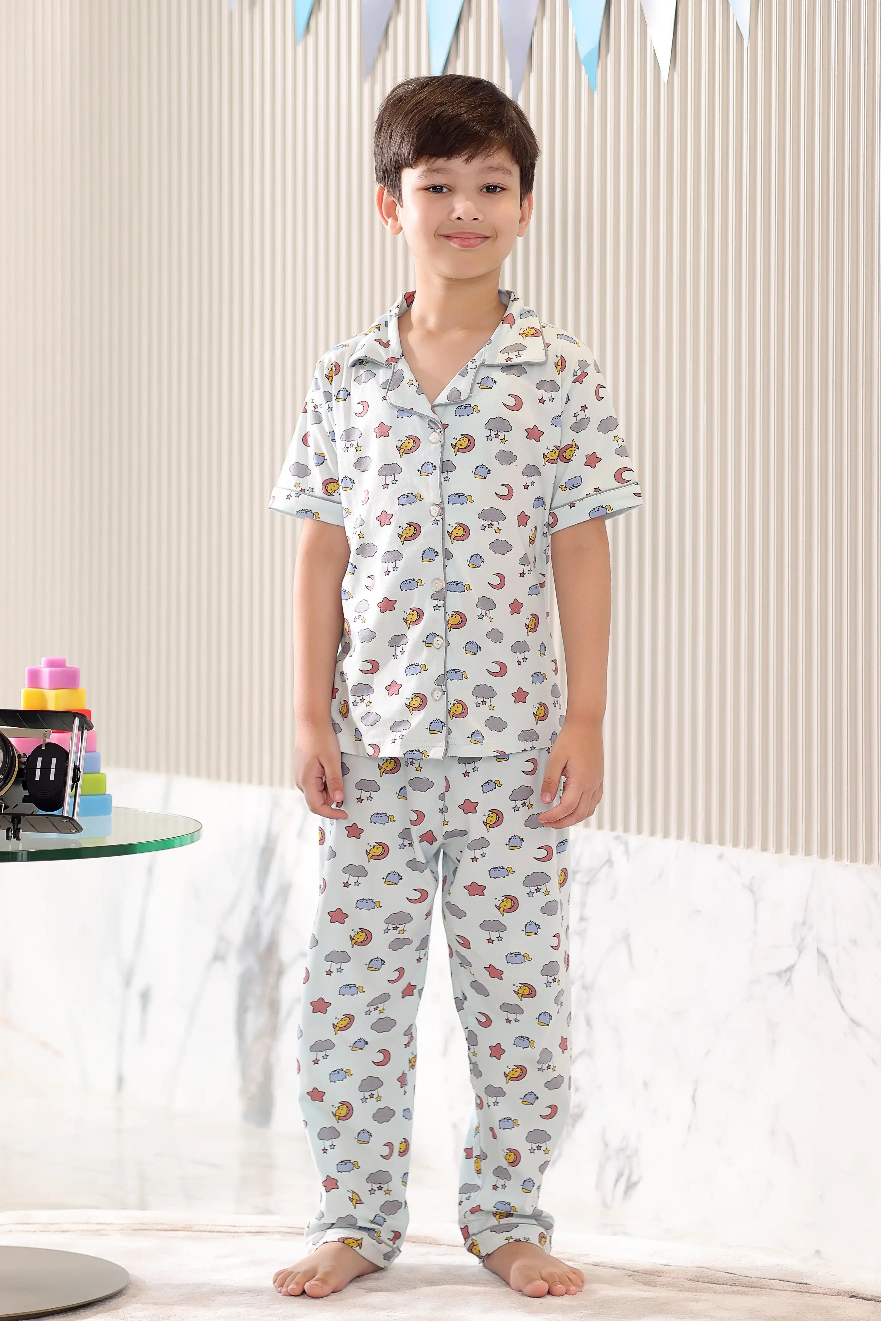 Child wearing a cloud-patterned pajama set in a living room setting