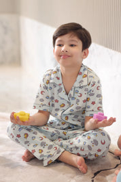 A child wearing cloud-patterned pajamas, sitting on a bed.