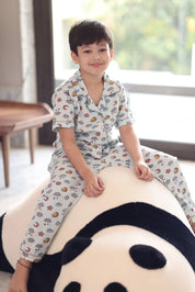 Child in a cloud print outfit, sitting on a large plush toy