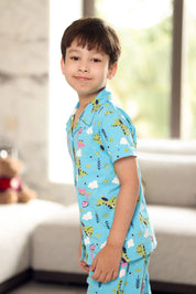 A child wearing a blue shirt with animal prints in a room.