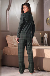 Woman wearing a green plaid suit standing in a modern living room.