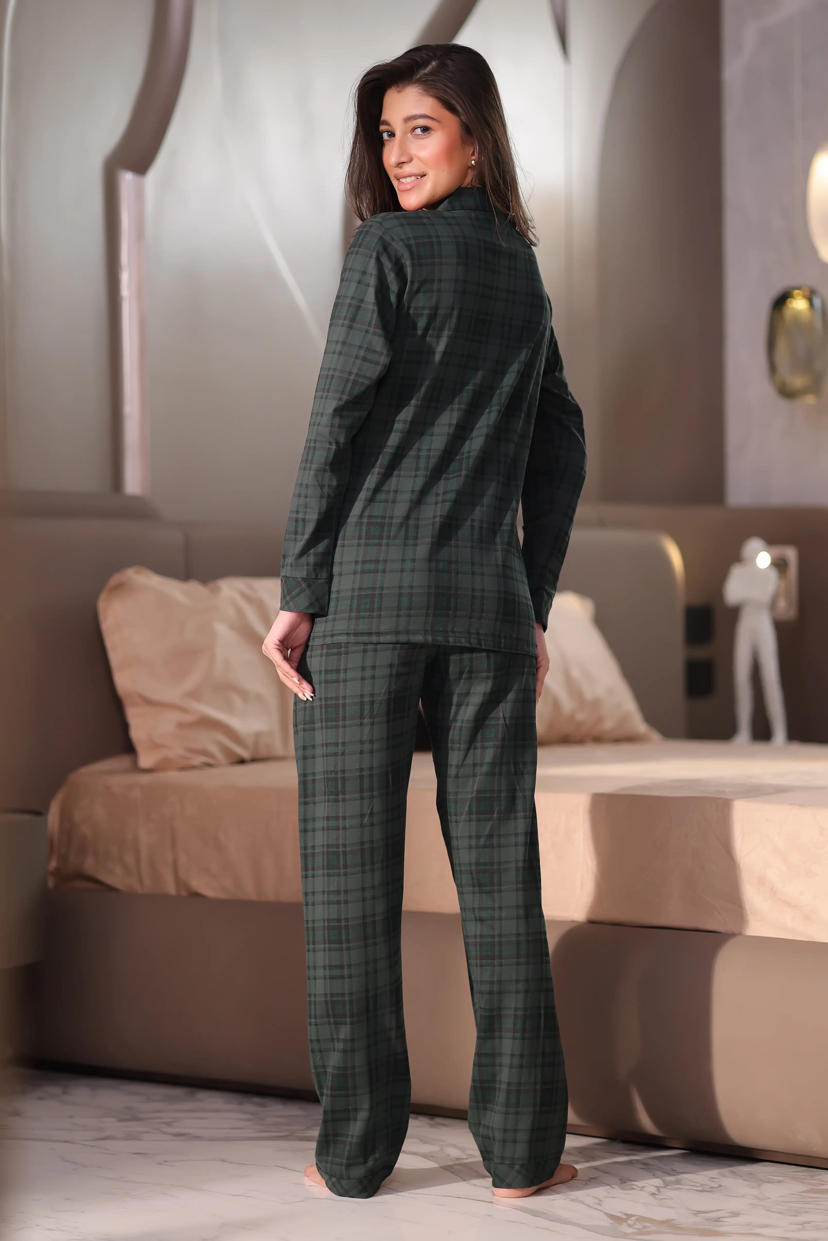Woman wearing a green plaid suit standing in a modern living room.