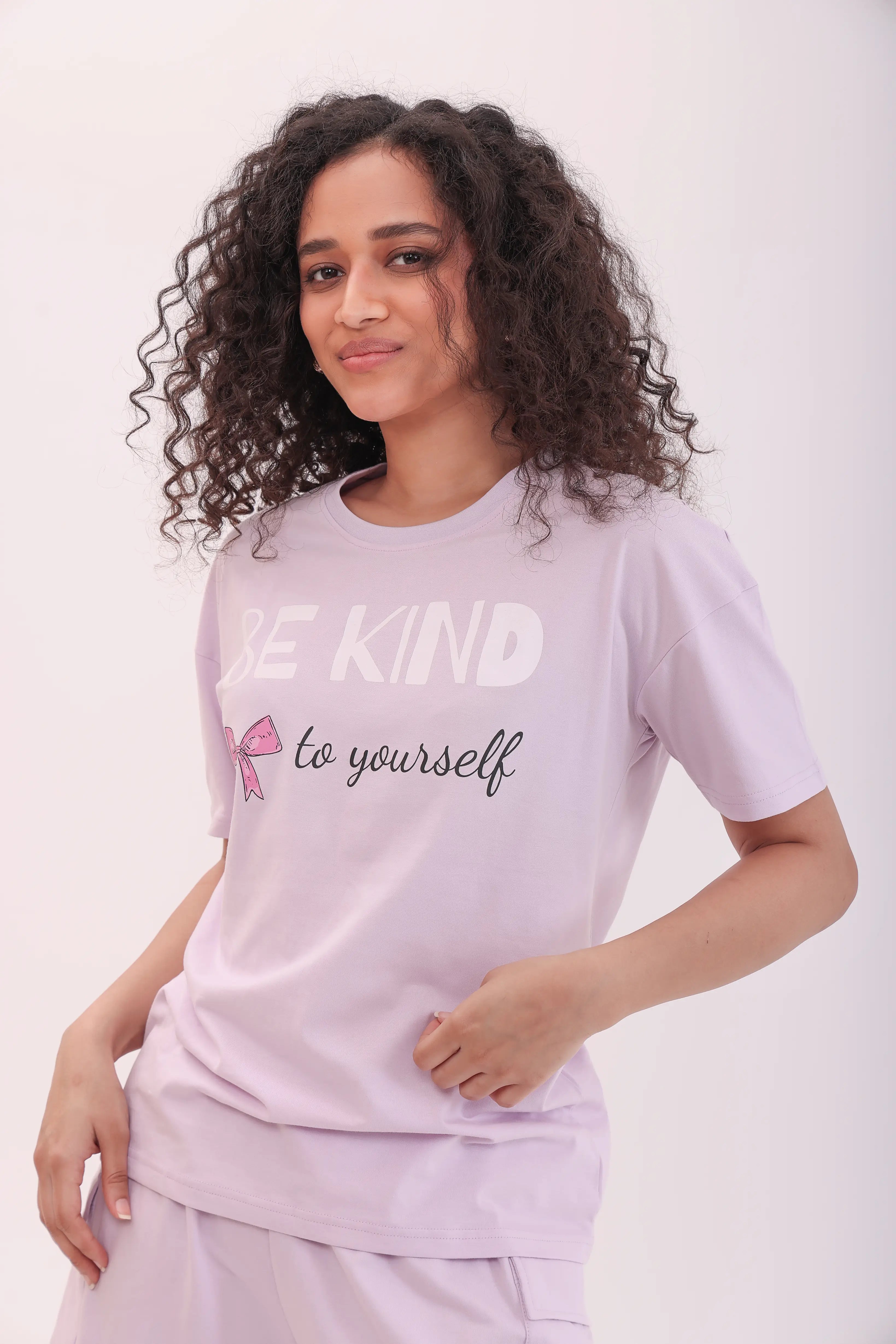 Woman wearing lavender oversized printed tee with ‘Be Kind to Yourself’ text by NapStory