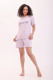 Full view of a woman in lavender printed oversized tee paired with shorts by NapStory