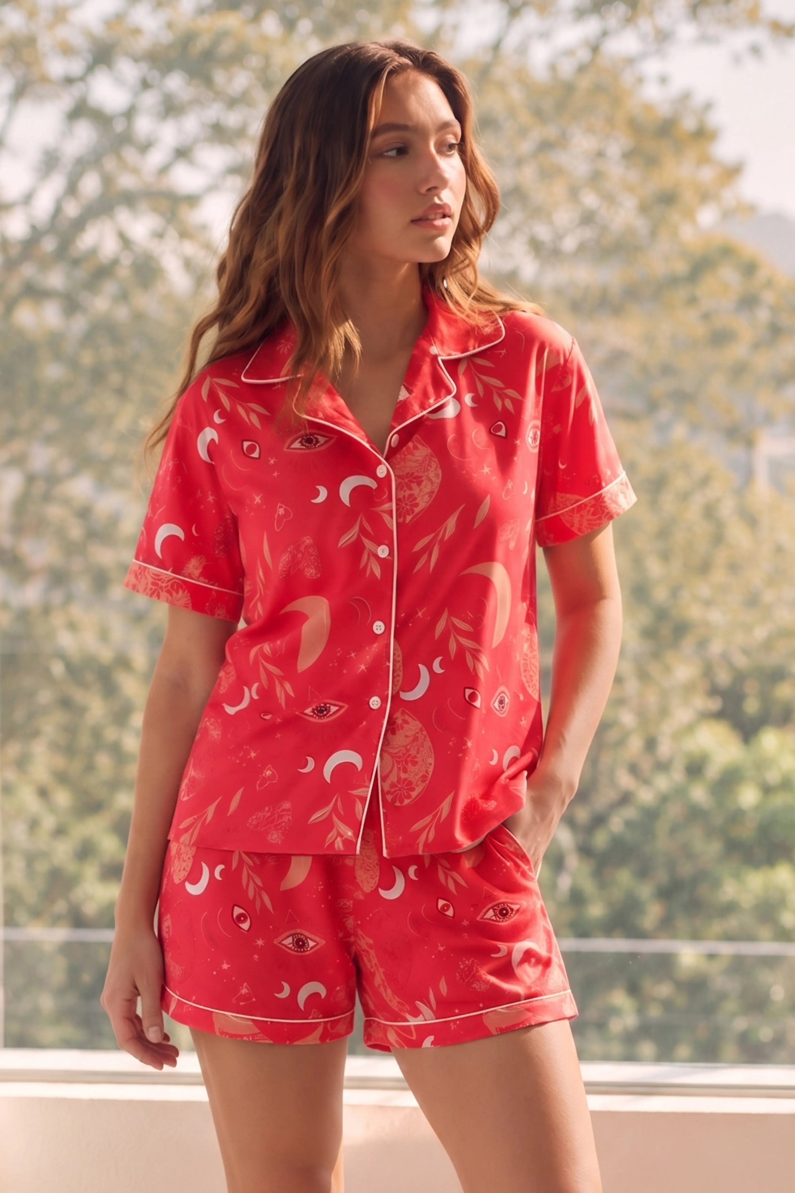 Woman wearing a red Shorts set with a floral pattern in a bright room.