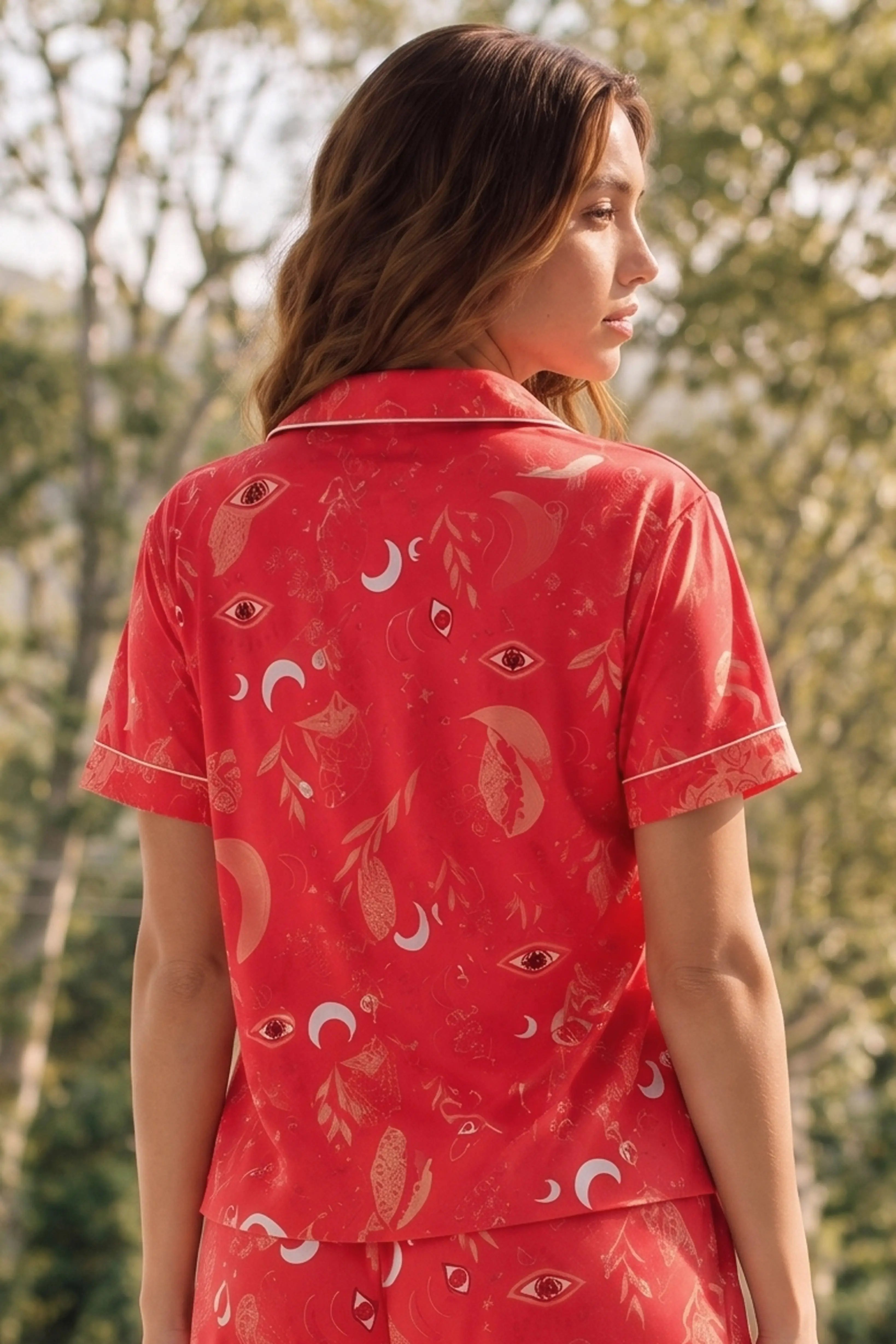 Woman wearing a red patterned shirt with nature in the background
