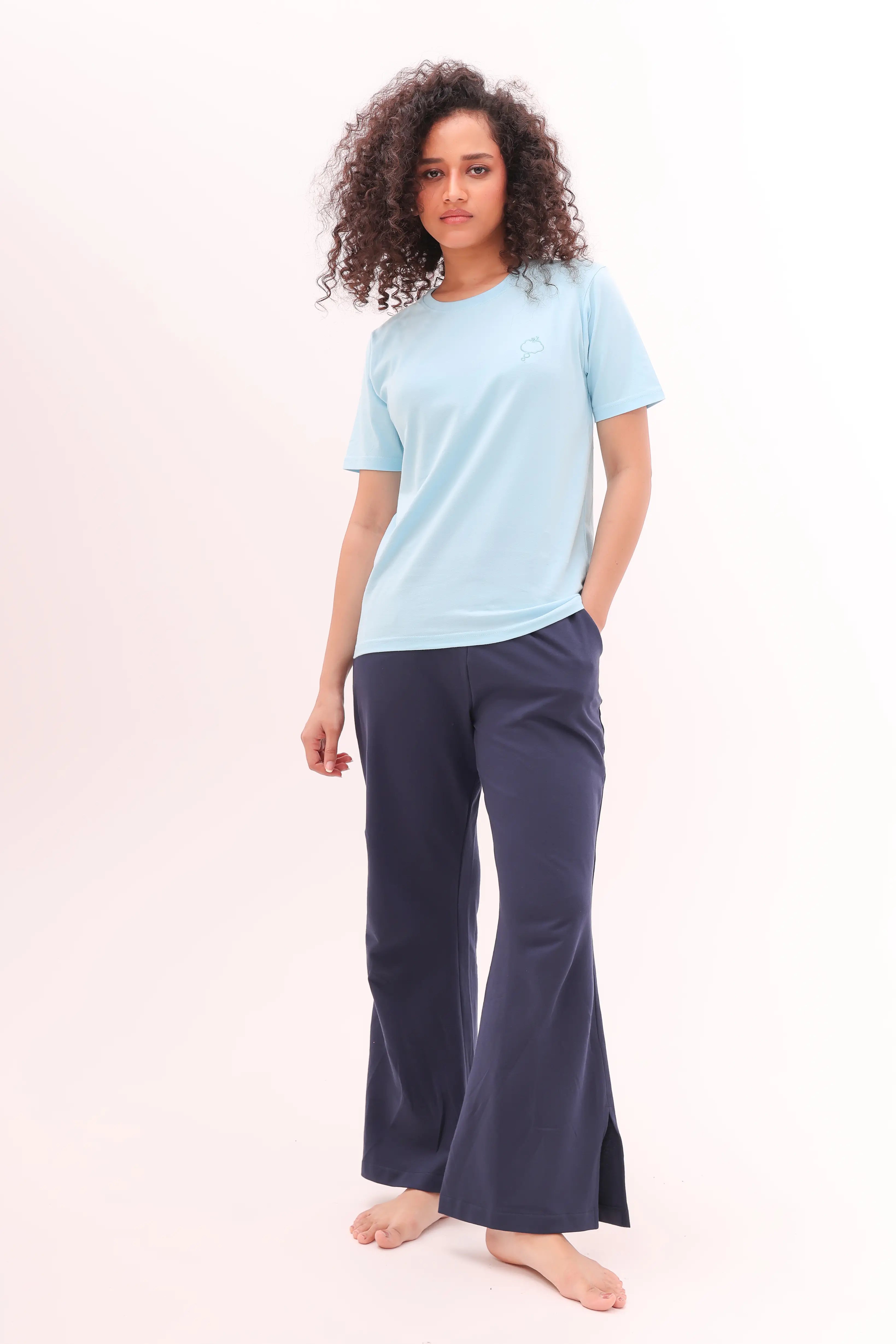 Woman standing wearing navy flared side slit pants and light blue top, loungewear by NapStory
