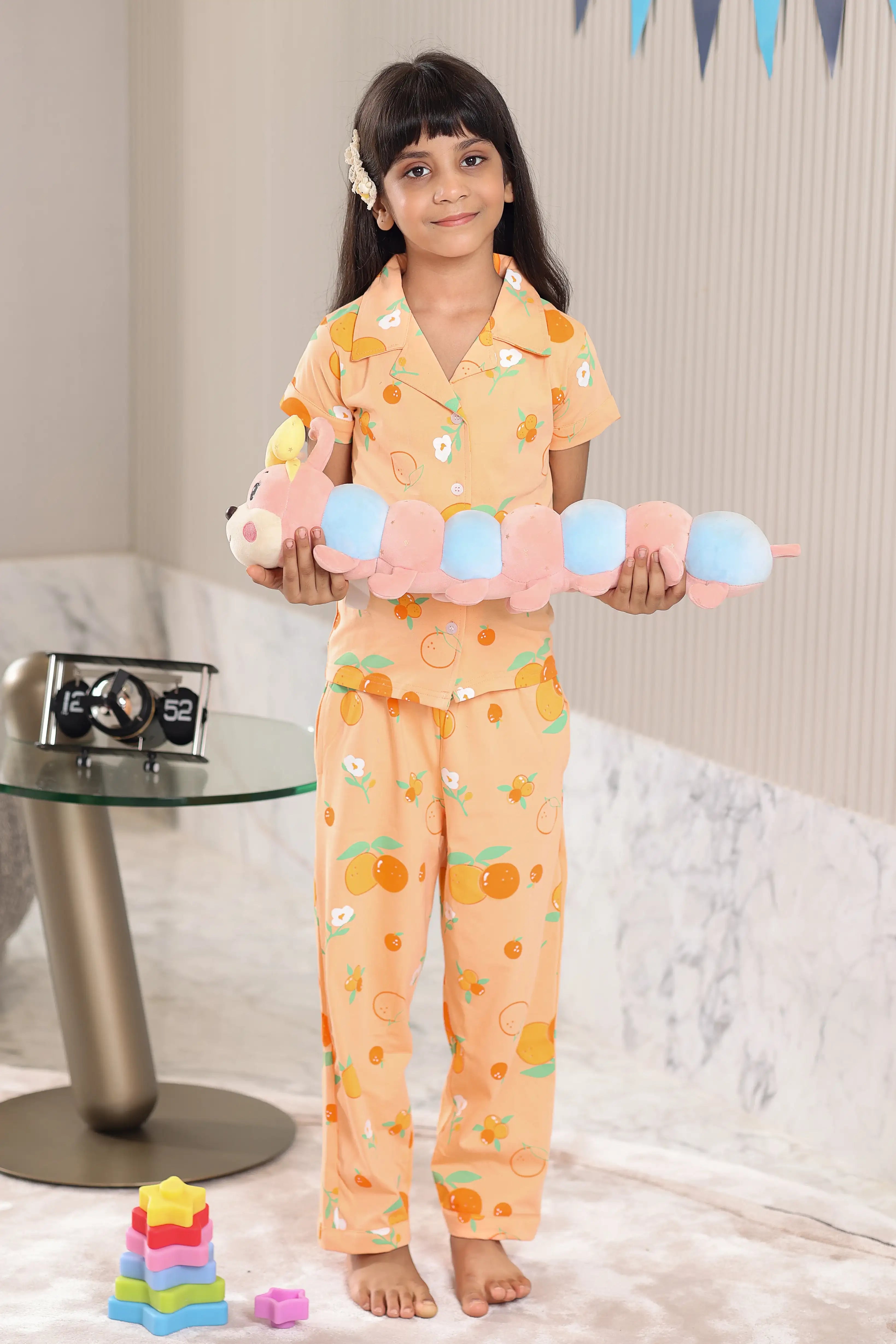 A child wearing a matching outfit with colorful toys in a room.