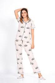 Young lady in a Panda Print Pyjama Set nightwear by NapStory, standing relaxed with her hand resting on her head.