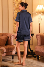 Woman wearing a navy blue shorts set in a cozy living room.