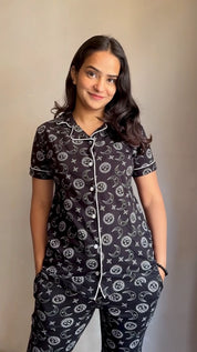 A girl in a black Star Moon Print Pyjama Set nightwear by NapStory