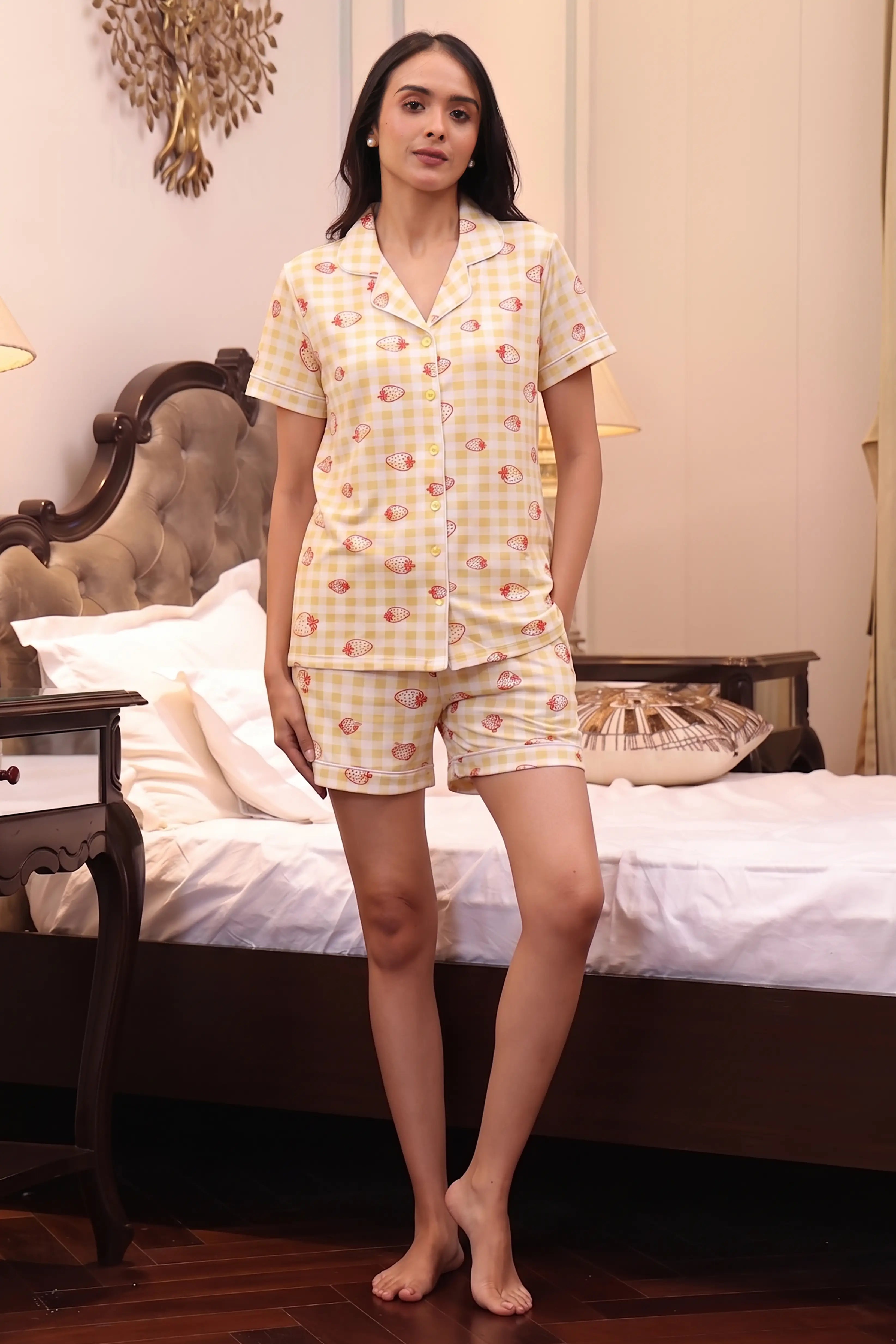 Woman wearing a yellow checkered Shorts set in a bedroom setting.