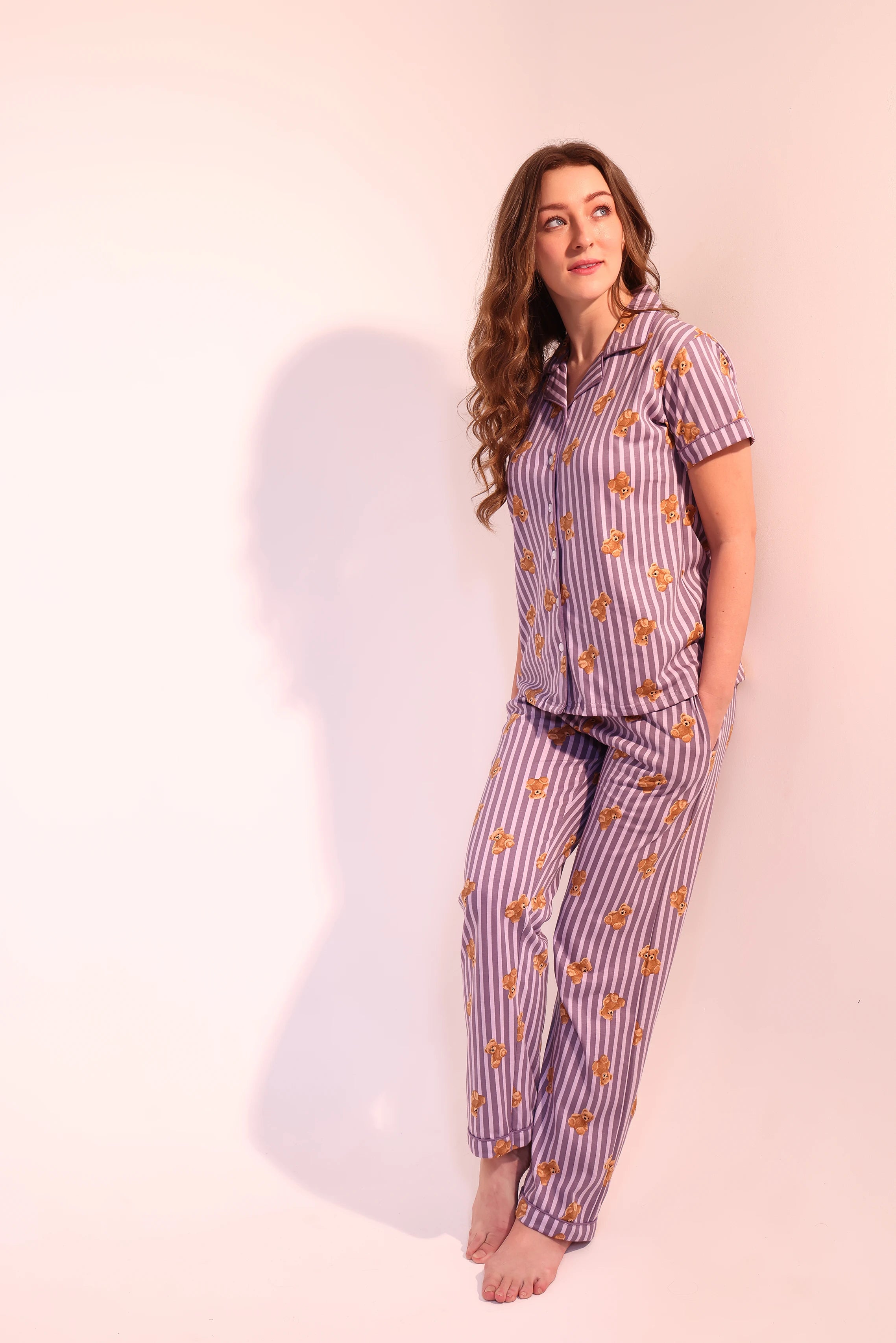 Woman standing barefoot and smiling in breathable Teddyboo print Pyjama Set nightwear by NapStory.