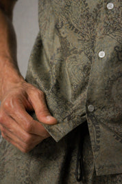 Close-up of a person wearing a patterned shirt with buttons.