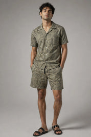 Man wearing a green camouflage outfit on a gray background