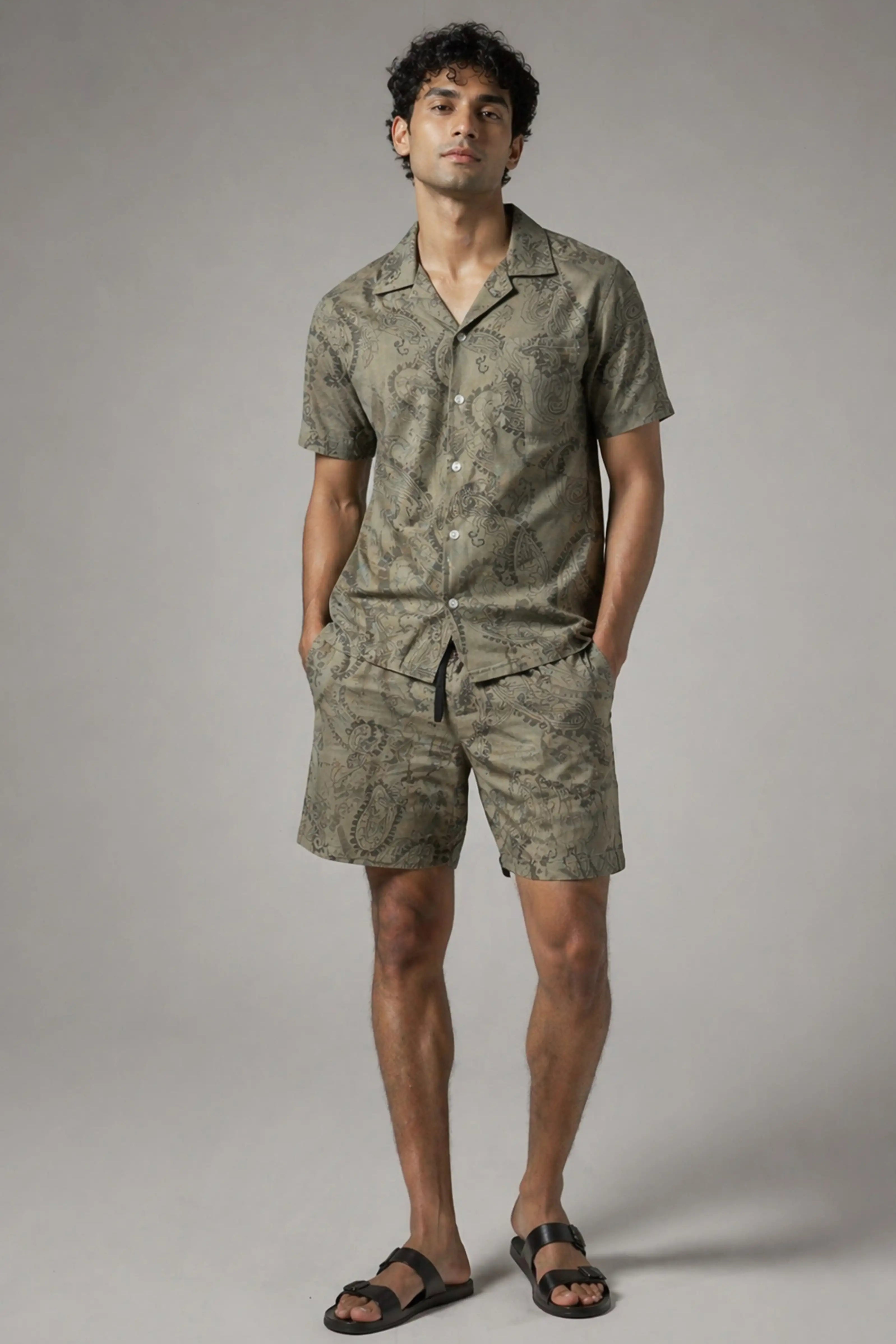 Man wearing a green camouflage outfit on a gray background