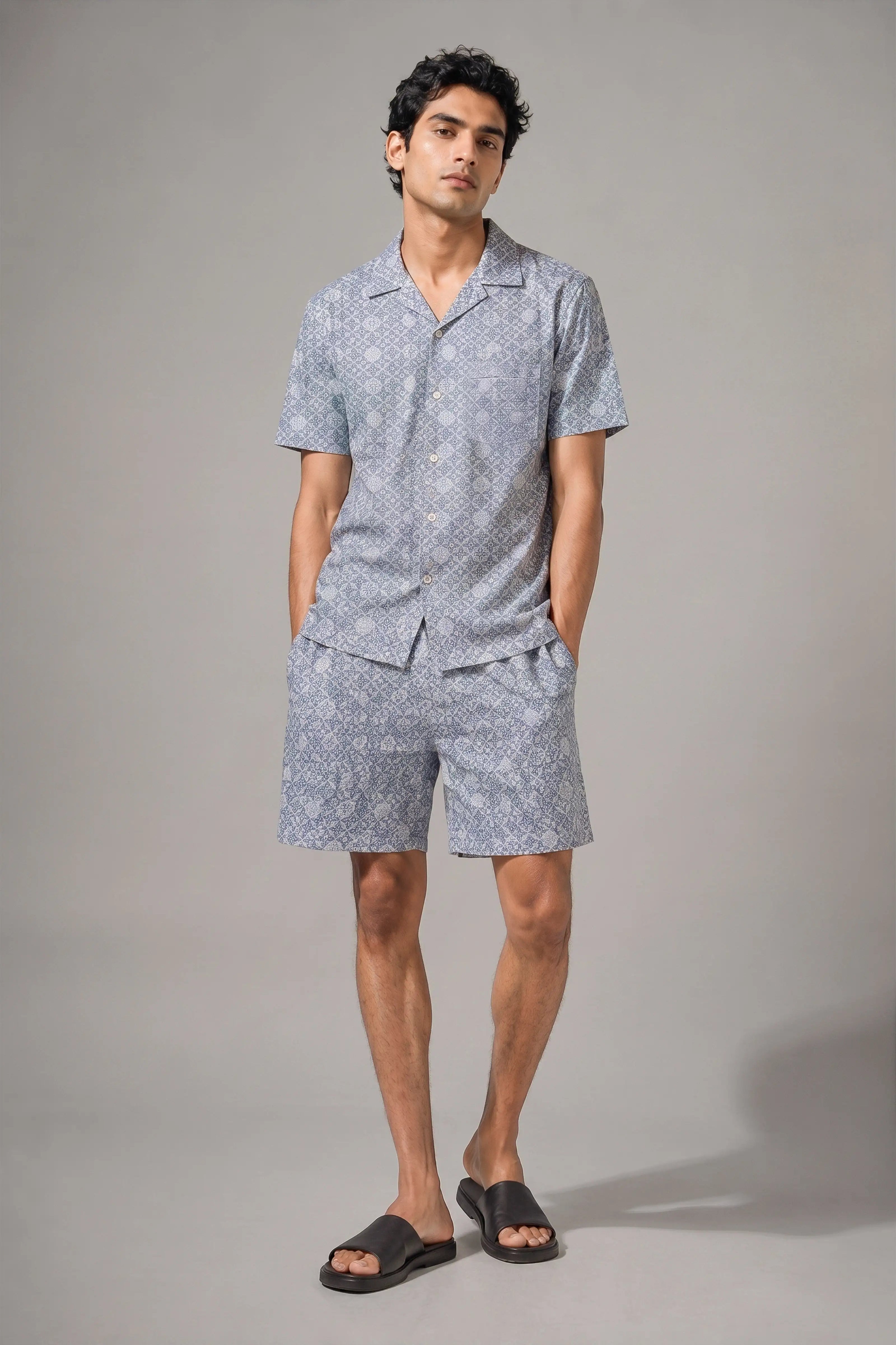 Man wearing a matching shirt and shorts set on a gray background