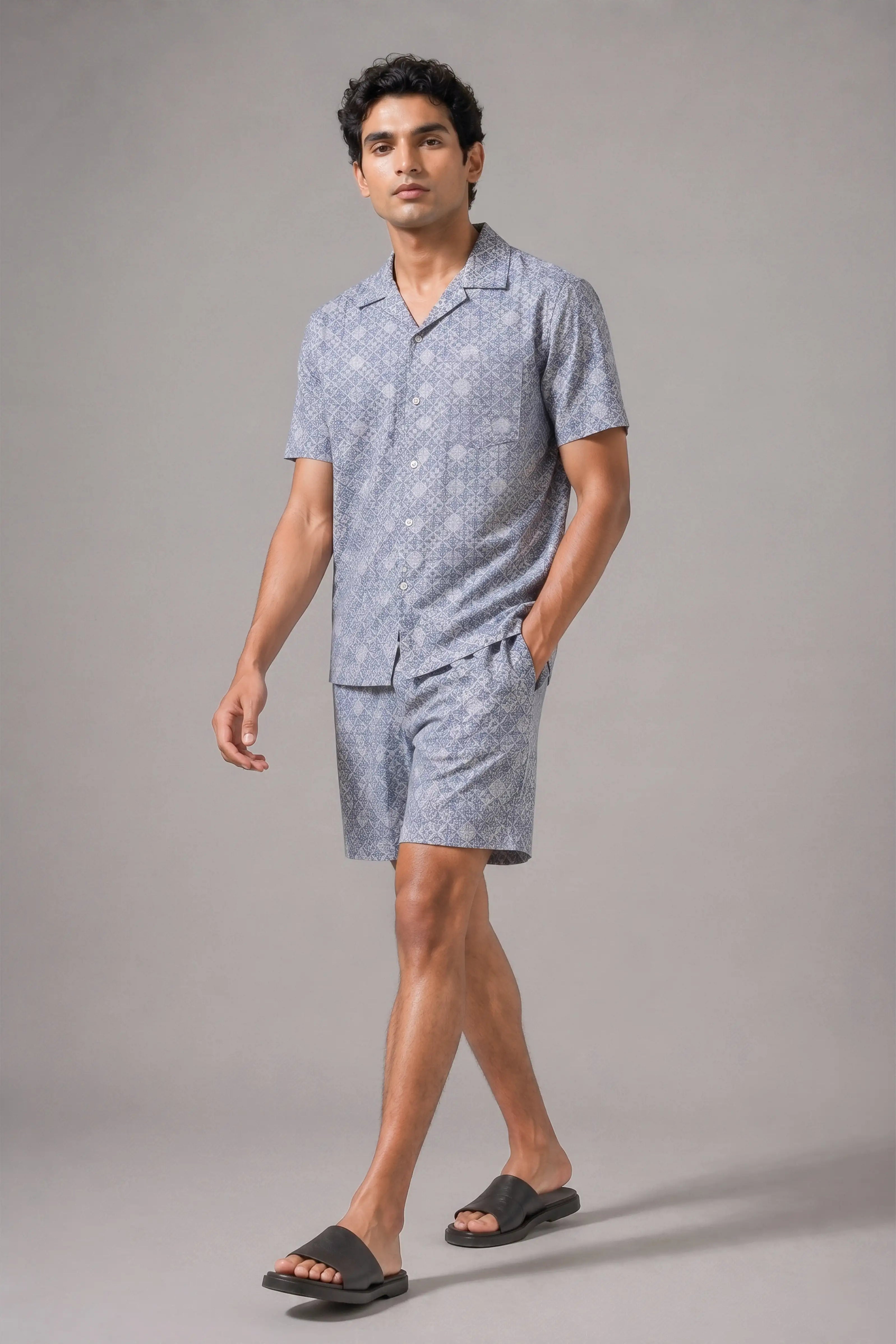 Man wearing a gray patterned pajama set on a gray background