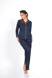Woman in a solid navy 100% cotton full sleeve nightsuit by NapStory, posing with a gentle smile and relaxed stance.
