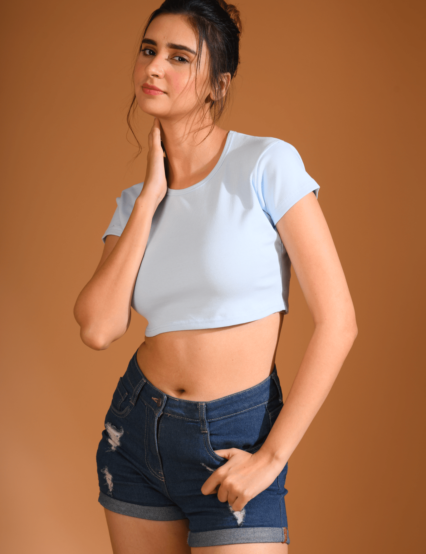 A young girl wearing a Sky Blue Baby Tee by NapStory, posing confidently with a stylish and relaxed vibe.